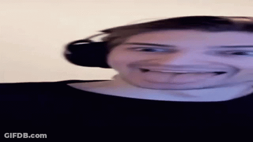 A Man Wearing Headphones Is Sticking His Tongue Out While Making A Funny Face . GIF