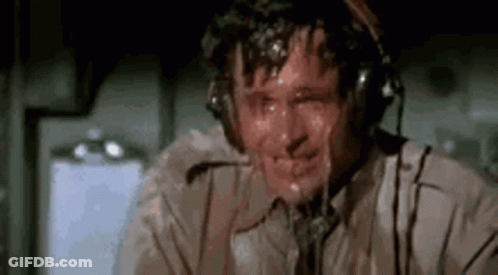 A Man Wearing Headphones Is Sweating While Sitting In A Plane . GIF