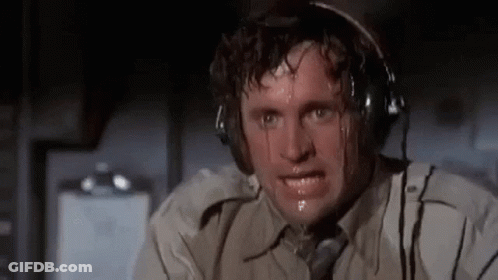 A Man Wearing Headphones Is Sweating While Sitting In An Airplane Cockpit . GIF