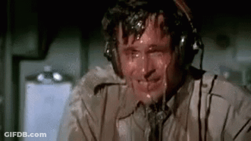 A Man Wearing Headphones Is Sweating While Sitting In An Airplane Cockpit . GIF