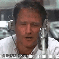 A Man Wearing Headphones Is Talking Into A Microphone And Saying Good Morning Gremlins . GIF