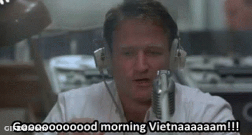 A Man Wearing Headphones Is Talking Into A Microphone And Saying Good Morning Vietnam . GIF