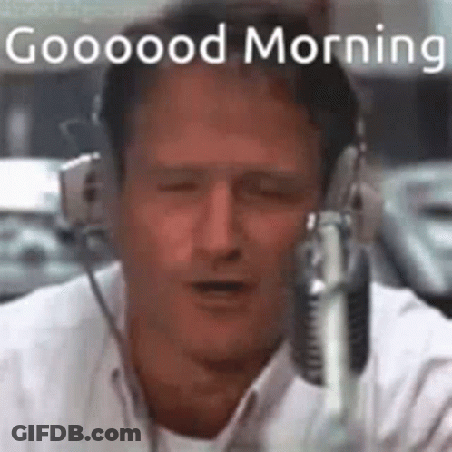 A Man Wearing Headphones Is Talking Into A Microphone And Saying Good Morning . GIF