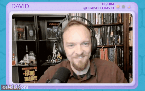 A Man Wearing Headphones Is Talking Into A Microphone And The Name David Is On The Screen Behind Him GIF