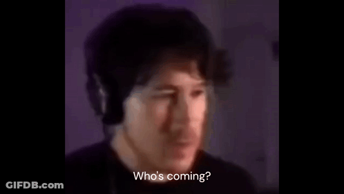 A Man Wearing Headphones Is Talking Into A Microphone In A Dark Room . GIF