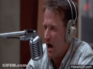A Man Wearing Headphones Is Talking Into A Microphone .. GIF