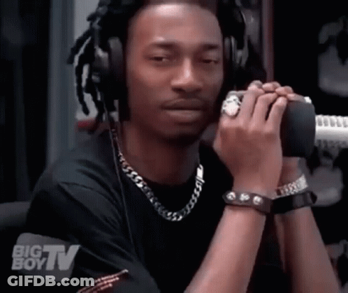 A Man Wearing Headphones Is Talking Into A Microphone With A Big Boy Tv Logo Behind Him GIF