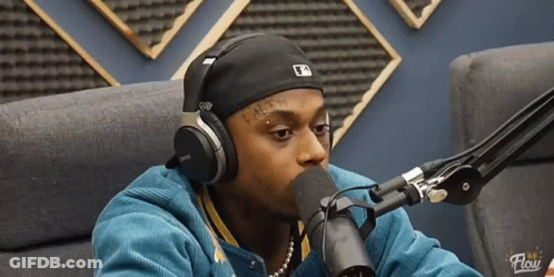 A Man Wearing Headphones Is Talking Into A Microphone With The Word Flow On The Bottom GIF