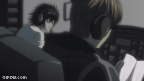A Man Wearing Headphones Is Talking To Another Man In A Dark Room GIF