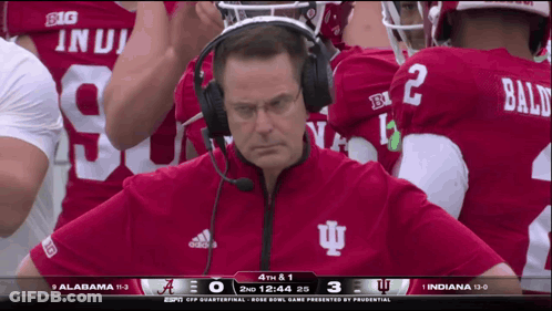 A Man Wearing Headphones Is Watching A Football Game Between Indiana And Alabama GIF