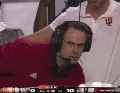 A Man Wearing Headphones Is Watching A Football Game Between Indiana And Iowa GIF