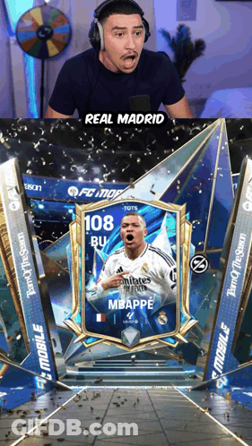 A Man Wearing Headphones Looks At A Card That Says Real Madrid On It GIF