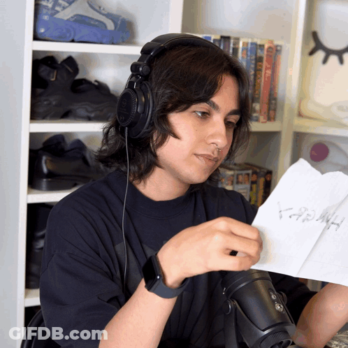A Man Wearing Headphones Looks At A Piece Of Paper That Says ' Hash ' GIF