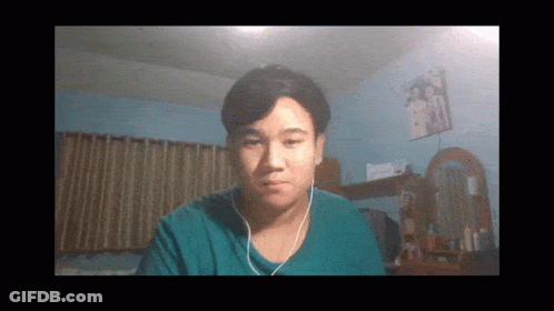 A Man Wearing Headphones Looks At The Camera In A Room GIF
