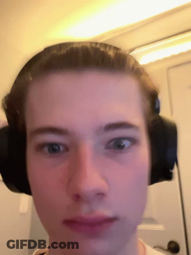 A Man Wearing Headphones Looks At The Camera GIF