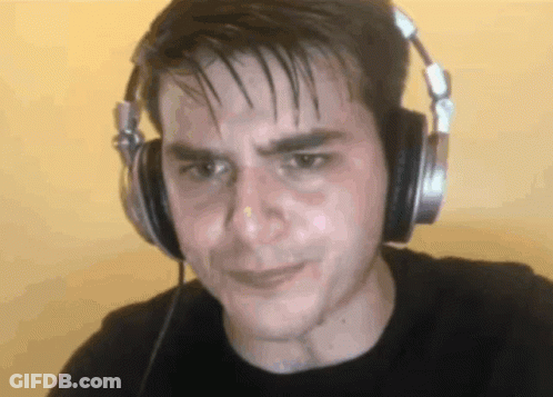 A Man Wearing Headphones Looks At The Camera With A Sad Look On His Face GIF