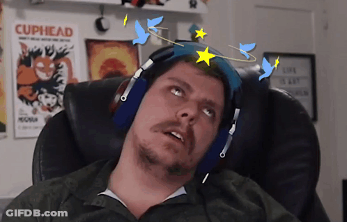 A Man Wearing Headphones Looks Up At A Cuphead Poster On The Wall GIF