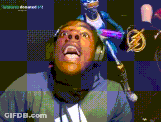 A Man Wearing Headphones Looks Up At A Statue Of A Superhero GIF