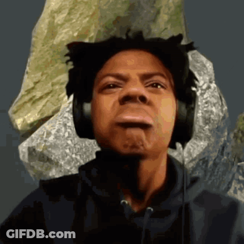 A Man Wearing Headphones Making A Funny Face In Front Of A Rock GIF