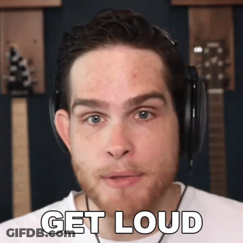 A Man Wearing Headphones Says " Get Loud " In Front Of A Guitar GIF