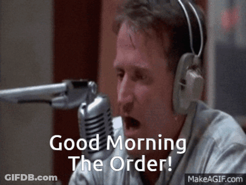 A Man Wearing Headphones Says " Good Morning The Order " In Front Of A Microphone GIF