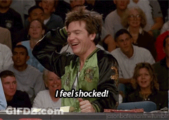 A Man Wearing Headphones Says " I Feel Shocked " In Front Of A Crowd GIF