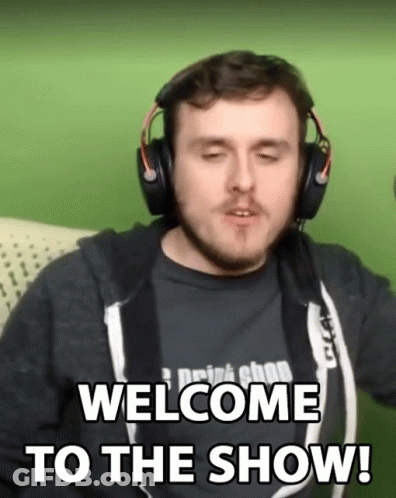 A Man Wearing Headphones Says Welcome To The Show While Sitting On A Couch GIF