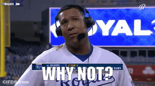 A Man Wearing Headphones Says Why Not In Front Of A Royals Sign GIF