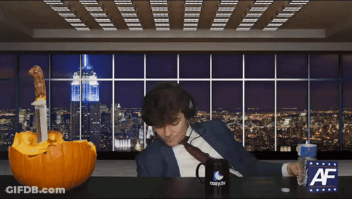 A Man Wearing Headphones Sits At A Table With A Cozy.tv Mug And A Pumpkin GIF