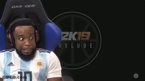 A Man Wearing Headphones Sits In A Chair With A 2K19 Relude Logo Behind Him GIF