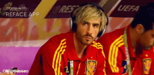 A Man Wearing Headphones Sits In A Locker Room With A Uefa Banner In The Background GIF