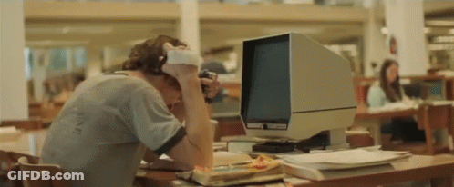 A Man Wearing Headphones Sits In Front Of A Computer Monitor GIF