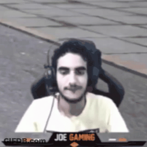 A Man Wearing Headphones Sits In Front Of A Joe Gaming Screen GIF