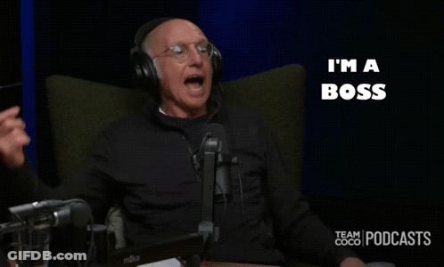 A Man Wearing Headphones Sits In Front Of A Microphone With The Words I 'M A Boss Behind Him GIF