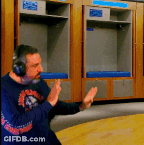 A Man Wearing Headphones Stands In Front Of A Locker Room With A Blue Cushion GIF