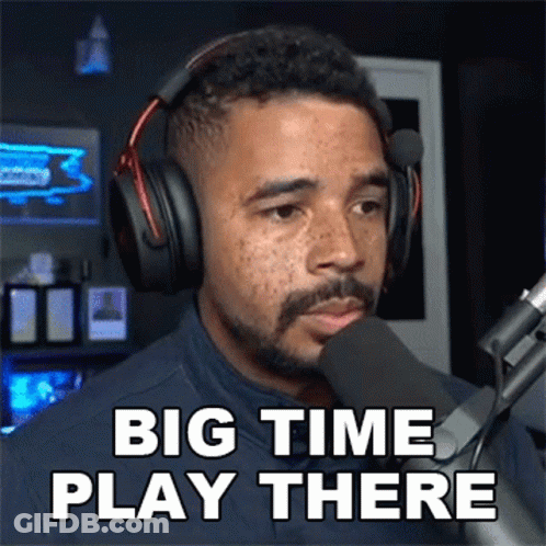 A Man Wearing Headphones Stands In Front Of A Microphone And Says Big Time Play There GIF
