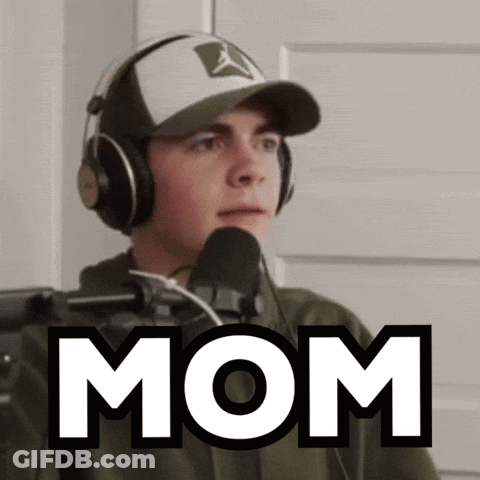 A Man Wearing Headphones Stands In Front Of A Microphone And Says Mom GIF