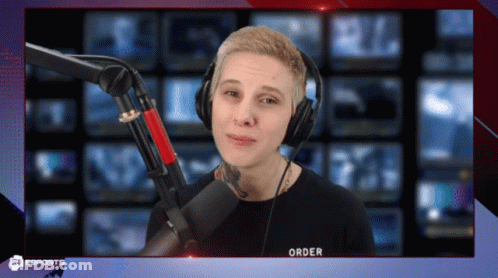 A Man Wearing Headphones Stands In Front Of A Microphone That Says Order On It GIF