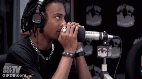 A Man Wearing Headphones Stands In Front Of A Microphone With A Big Boy Tv Logo In The Background GIF