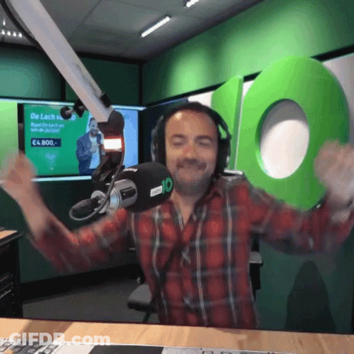 A Man Wearing Headphones Stands In Front Of A Microphone With The Number 10 Behind Him GIF