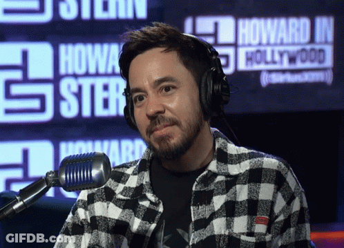 A Man Wearing Headphones Stands In Front Of A Sign That Says Howard J. Hollywood GIF