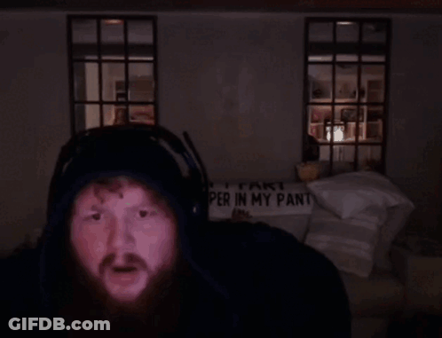 A Man Wearing Headphones Stands In Front Of A Sign That Says " Part Per In My Pant " GIF