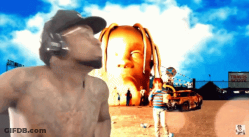 A Man Wearing Headphones Stands In Front Of A Sign That Says " Travis Scott " On It GIF