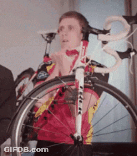 A Man Wearing Headphones Stands Next To A Bike With The Word Trek On It GIF