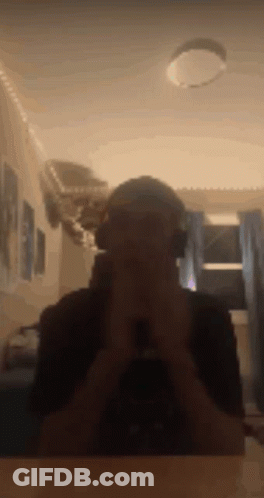 A Man Wearing Headphones Takes A Picture Of Himself In A Mirror . GIF