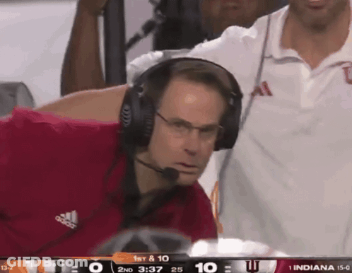A Man Wearing Headphones Watches A Football Game Between Indiana And Ucsd GIF