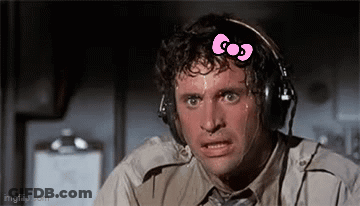 A Man Wearing Headphones With A Pink Bow On His Head Is Sweating . GIF