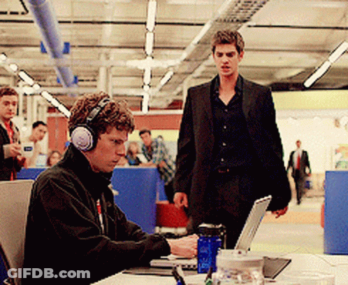 A Man Wearing Headphones Works On A Laptop GIF