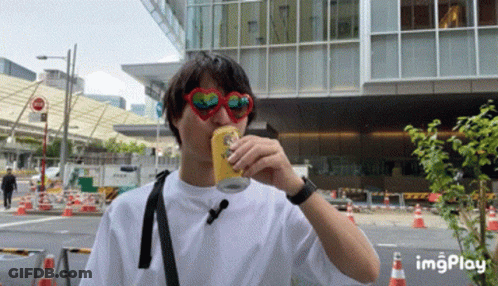 A Man Wearing Heart Shaped Sunglasses Drinks A Can Of Beer GIF