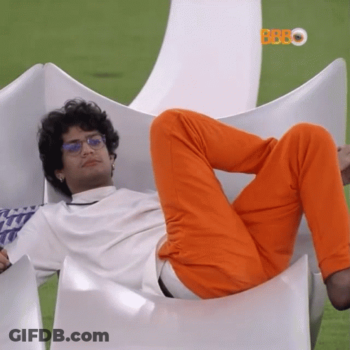 Man In Orange Pants And Glasses Laying On White Chair GIF